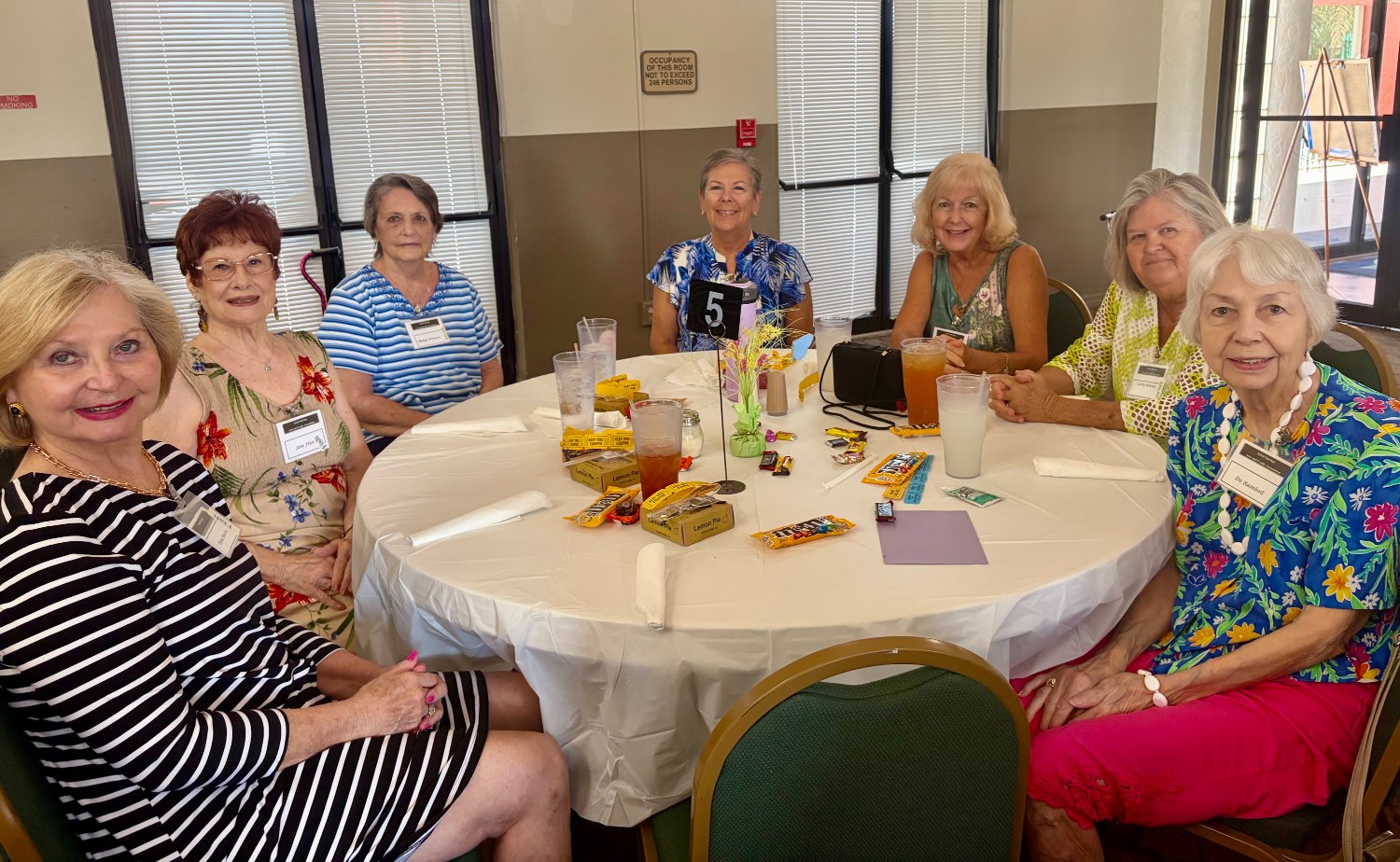 Arts & Crafts members gathered at a luncheon table with treats
