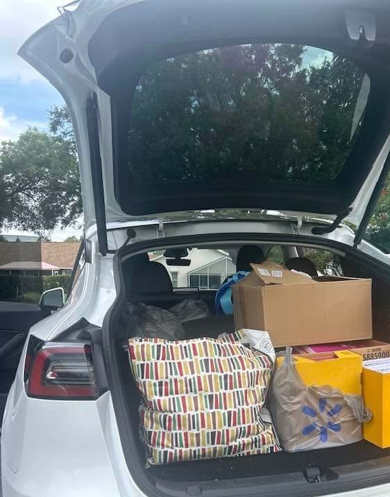 Car hatch packed with bags and boxes of donated back-to-school supplies