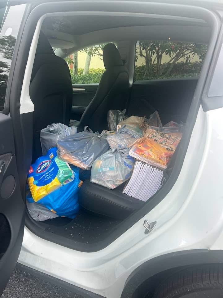 Back seat of a car filled with bags of donated school supplies