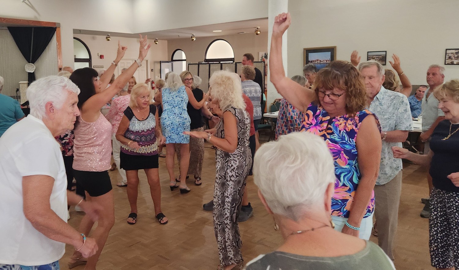SunShine Singles dancing with arms raised to Bandstand’s music at the clubhouse