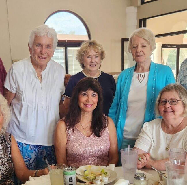 SunShine Singles group posing together around a restaurant table