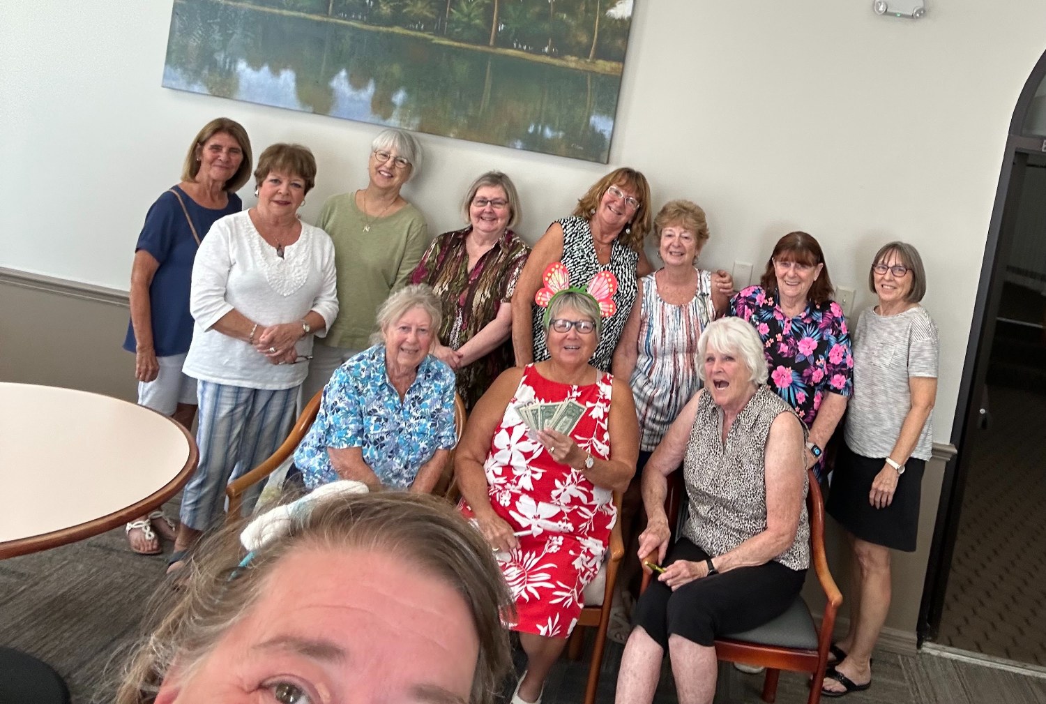 SunShine Singles in the card room as Shirley holds up her fan of Bunco winnings