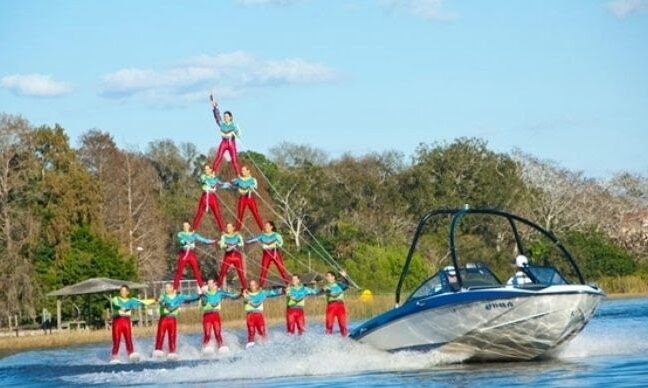 Cypress Gardens Water Ski Team forms a four-tier human pyramid behind a boat