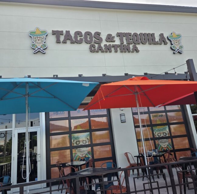 Tacos and Tequila Cantina storefront with turquoise and red patio umbrellas