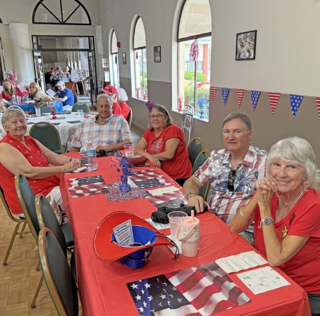 Clubhouse event room full of residents at a patriotic party