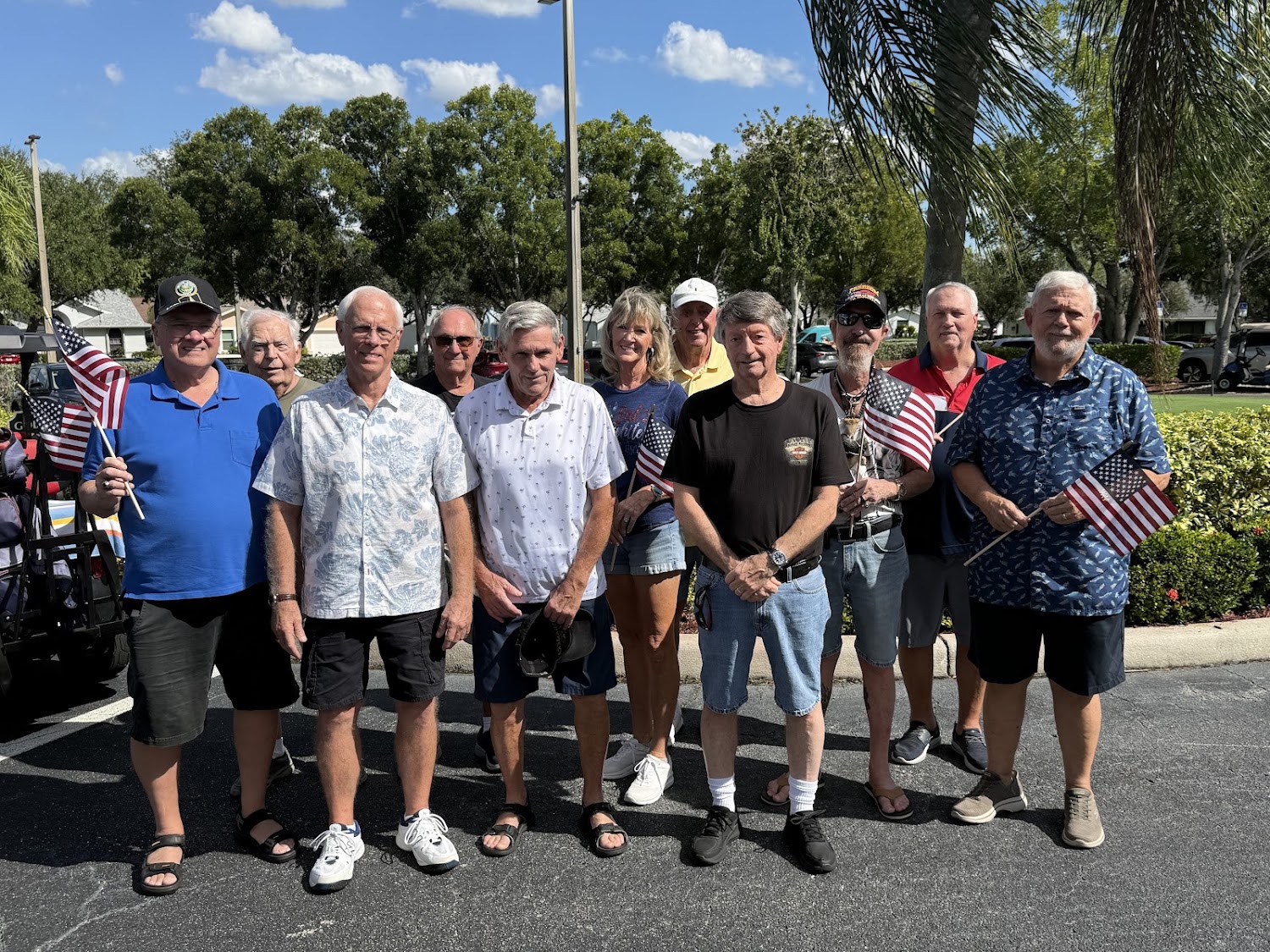 Sabal Springs Army veterans with American flags outside the Clubhouse.