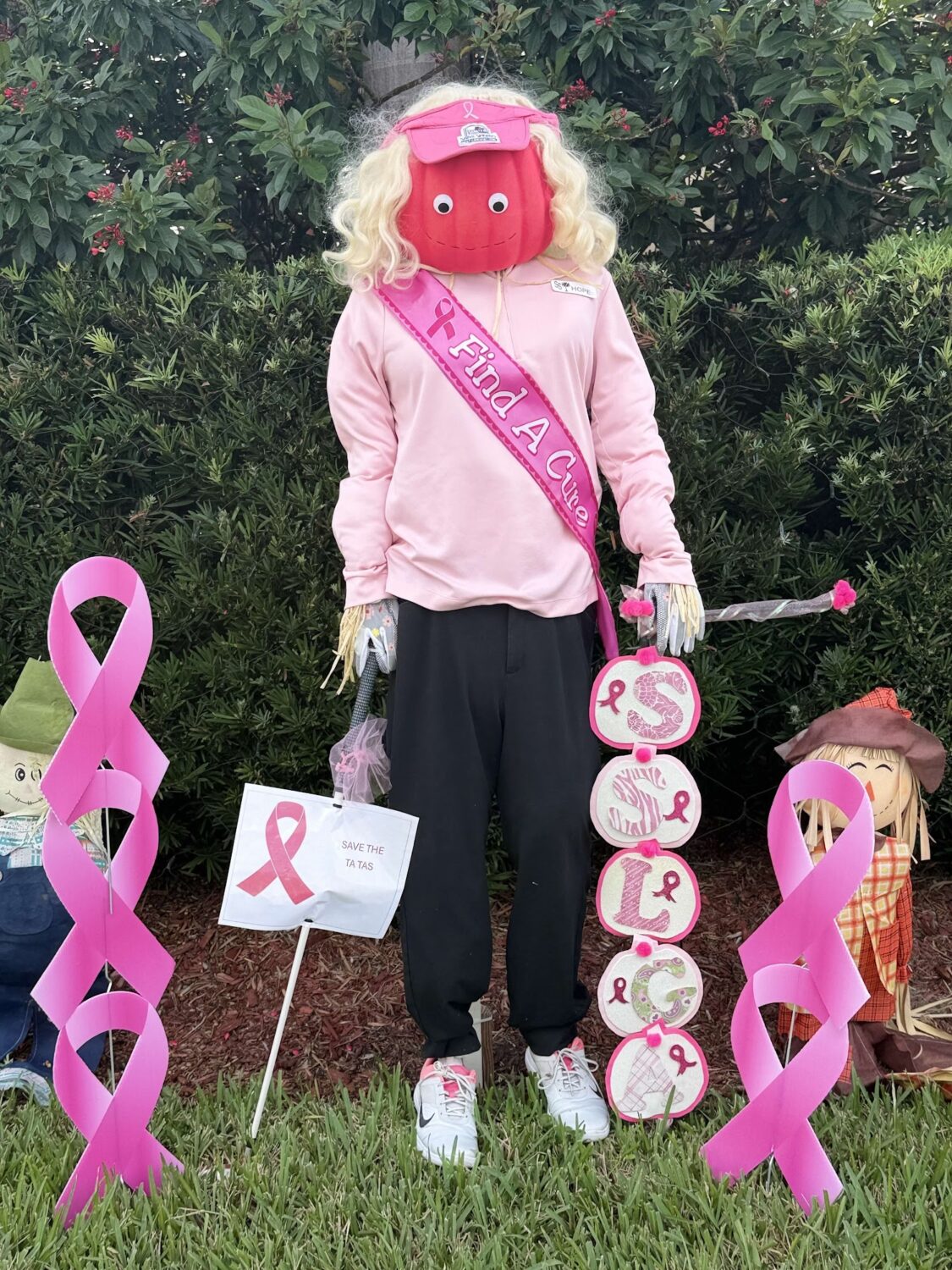 Pink breast cancer awareness scarecrow with ribbons from the Ladies Golf Association.