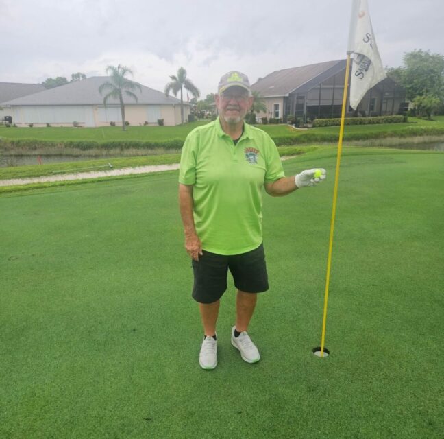 Gary Clapp standing beside the flagstick on the ninth green.