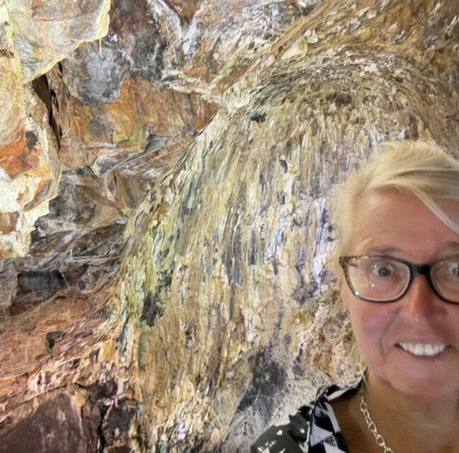 Traveler inside a dormant volcano with colorful rock striations.