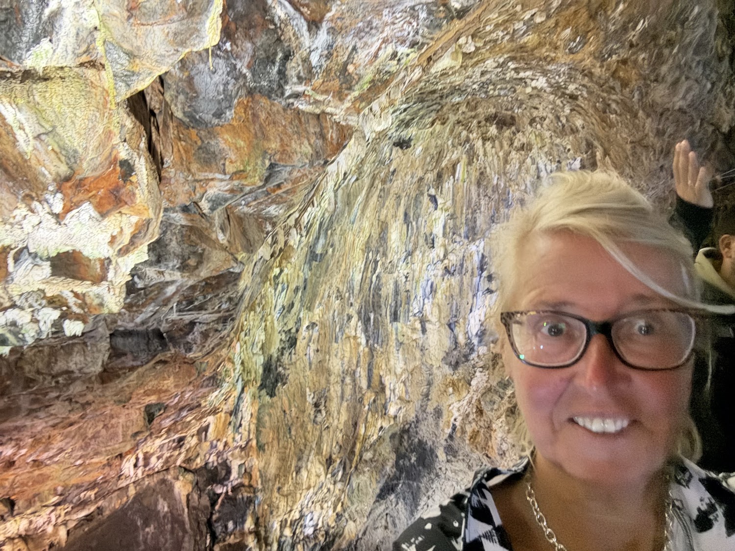 Traveler inside a dormant volcano with colorful rock striations.