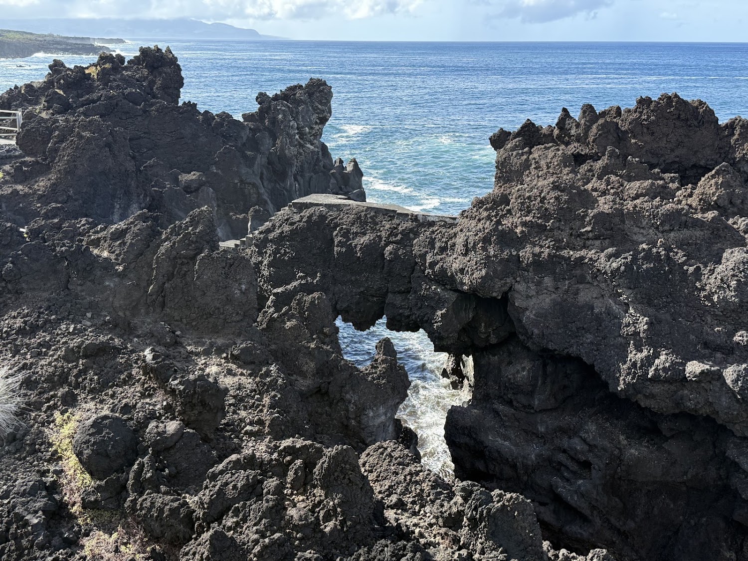 Jagged black lava arches along the Azores coastline.
