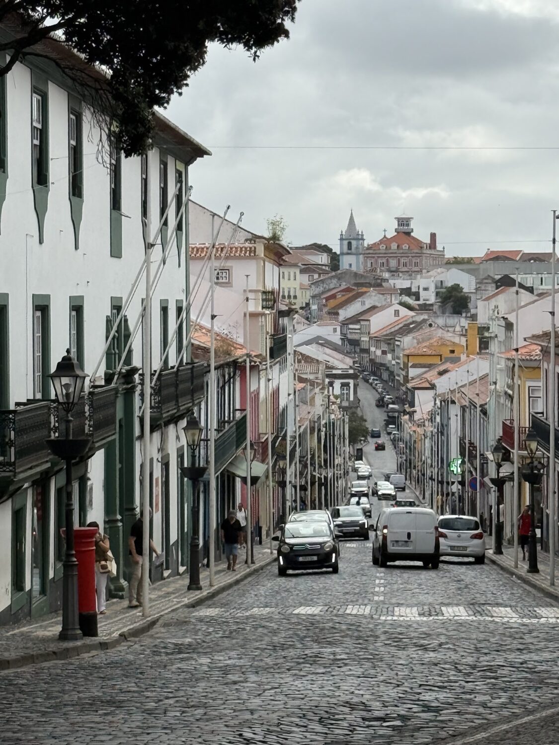 Cobblestone street lined with white buildings in Angra, Terceira.